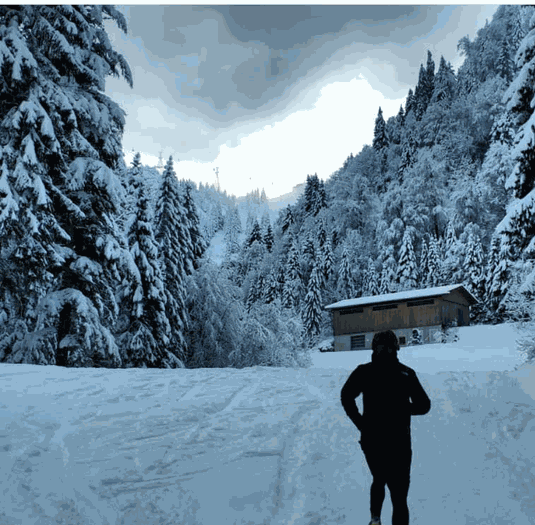 Person running through a snowy mountain