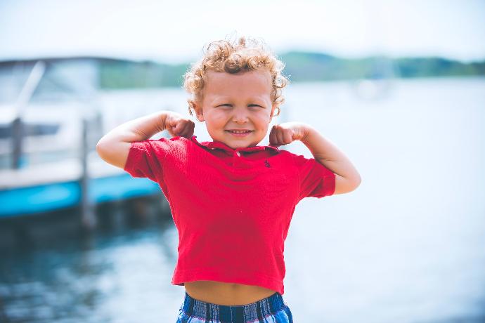 Un bambino che mostra i suoi muscoli con l'aiuto del potassio