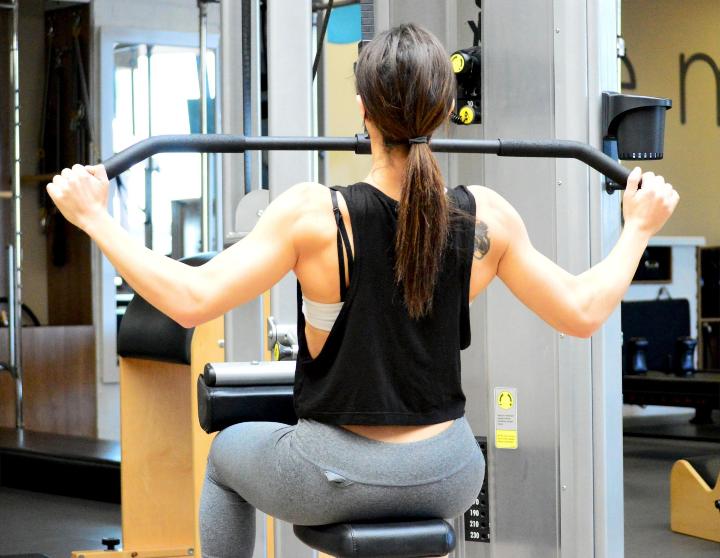 Een vrouw die lichaamstraining doet in de sportschool met gewichten