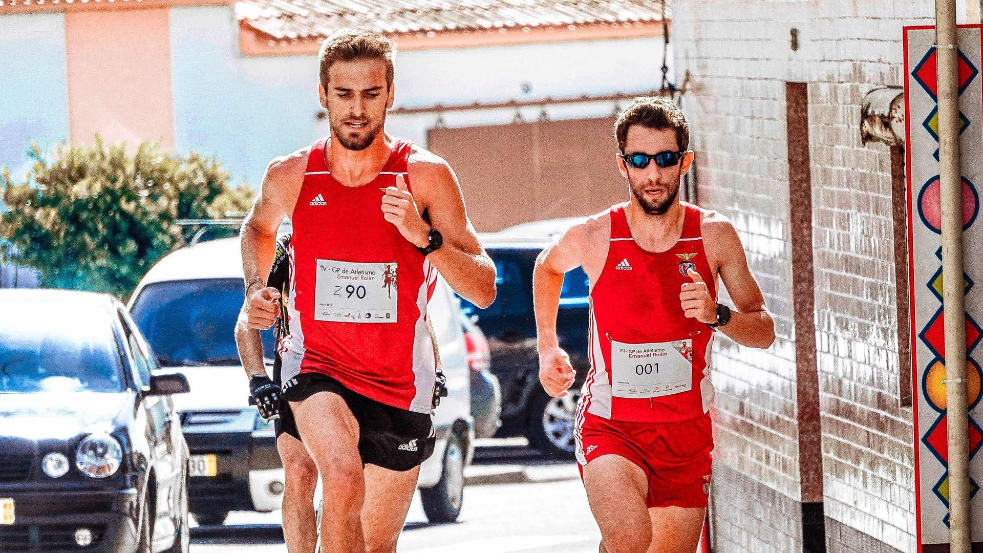 Dos corredores masculinos haciendo un maratón con camiseta roja
